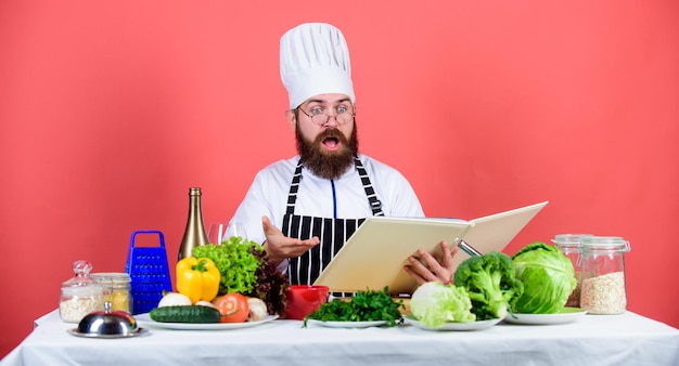 Cucina leggere libri ricette Uomo impara ricetta Prova qualcosa di nuovo Cucina nella mia mente Abilità di cucina Prenota ricette Secondo ricetta Chef uomo barbuto che cucina cibo Controlla se hai tutti gli ingredienti