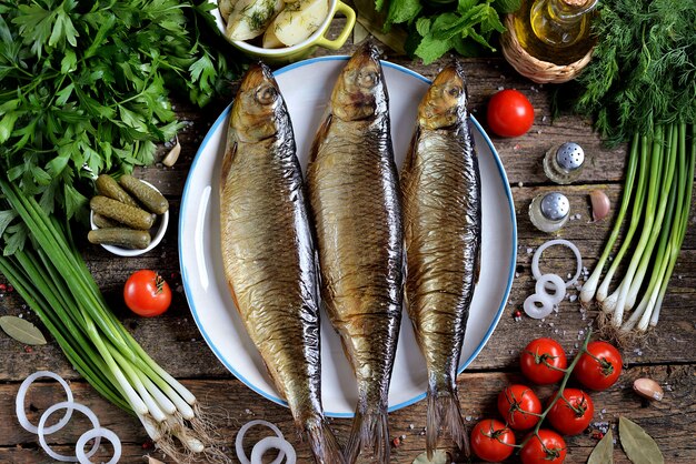 Cucina mediterranea: aringa affumicata con patate lesse, olive secche, cipolle verdi e cetrioli sottaceto. Stile rustico.