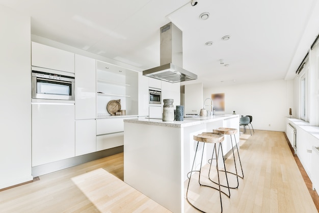 Cucina moderna con armadi in legno e design minimalista in appartamento monolocale mansardato con pareti bianche