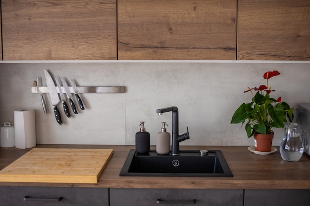Cucina moderna in colori grigi e armadi in legno a casa con stoviglie