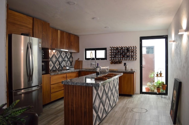 Cucina moderna in legno con barra in granito nero o grigio con pavimento in piastrelle backsplash chiaro