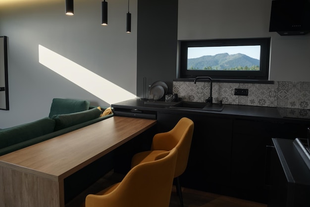 Cucina nera moderna con sedie da pranzo gialle con spazio per la copia