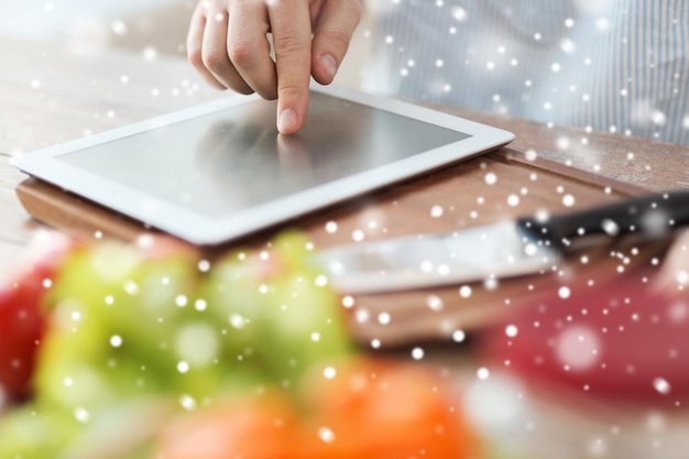 cucina, persone, tecnologia e concetto di casa - primo piano dell'uomo che legge la ricetta dal computer tablet pc e verdure sul tavolo in cucina