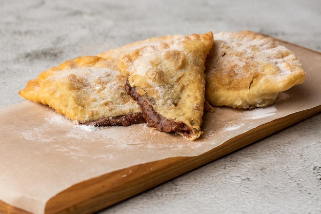 Cucina tartara orientale uzbeka dolce cheburek su una tavola di legno Torta fritta Cheburek con cioccolato