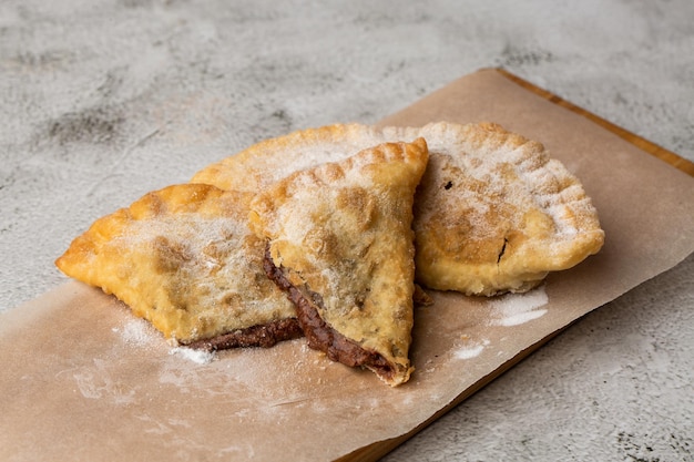 Cucina tartara orientale uzbeka dolce cheburek su una tavola di legno Torta fritta Cheburek con cioccolato