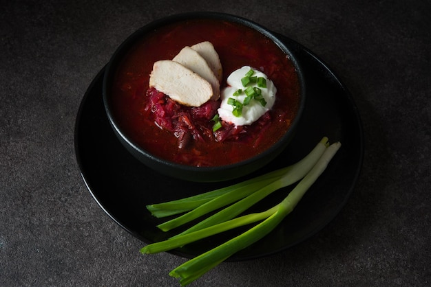 Cucina tradizionale ucraina - borscht con panna acida e cipolle verdi, primo piano