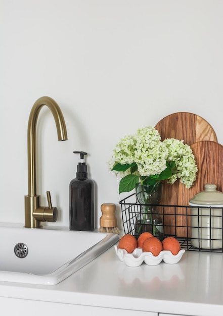 Cucina vista la mattina tagliere di tavole di legno un bouquet di ortensie in un cesto di uova in un supporto in ceramica sul tavolo della cucina