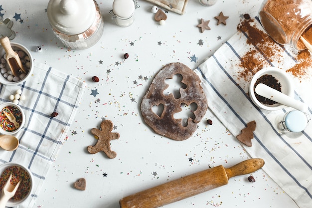 Cucinando i biscotti dello zenzero sulla cucina di notte di Natale a casa