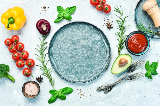 Cucinare Cibo sfondo Verdure spezie e una piastra di metallo su uno sfondo di pietra grigia Vista dall'alto Spazio libero per il testo