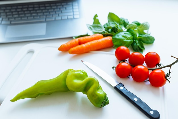 cucinare con i dispositivi ricetta online. Verdure fresche per fare l'insalata sul tagliere