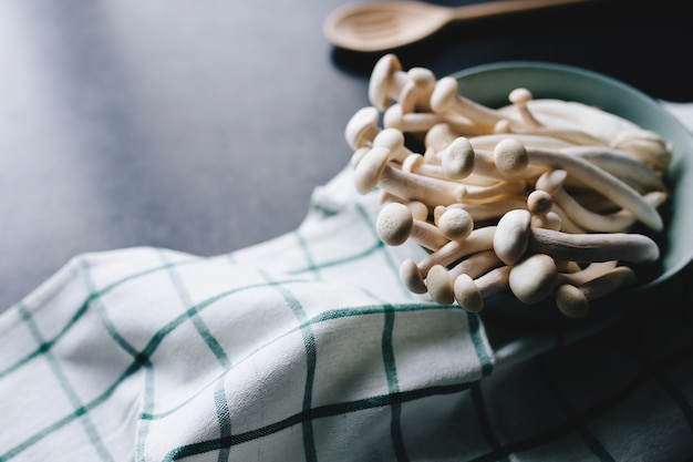 Cucinare funghi bianchi su sfondo grigio scuro. Foto di alta qualità