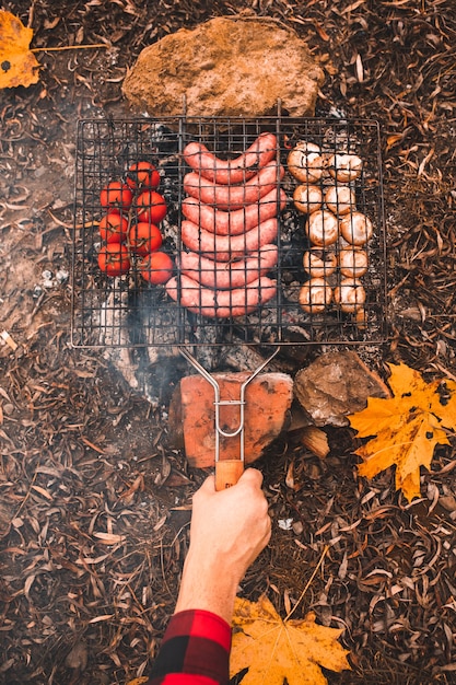 Cucinare il cibo sul falò. concetto di campeggio. avvicinamento