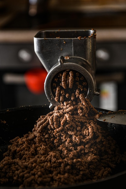 Cucinare il patè di pollo attraverso un tritacarne. Cucinare cibi fatti in casa.