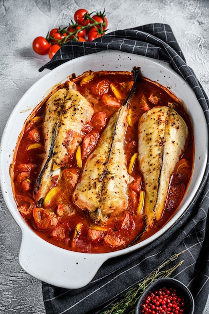 Cucinare in pomodori rana pescatrice in una teglia. Pesce fresco