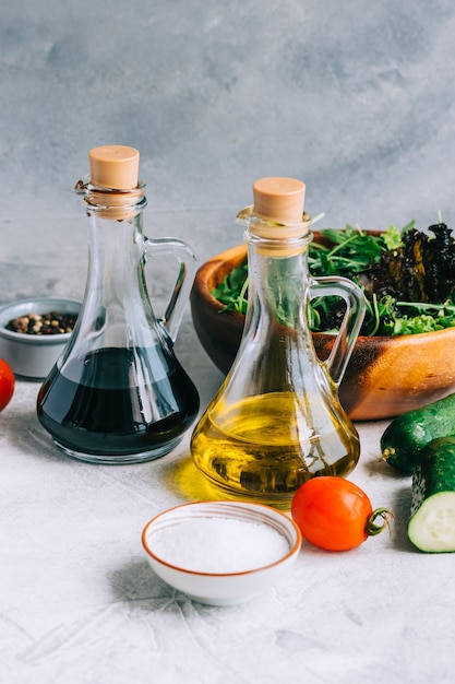 Cucinare insalata fresca, ingredienti sul tavolo con olio d'oliva e aceto balsamico.