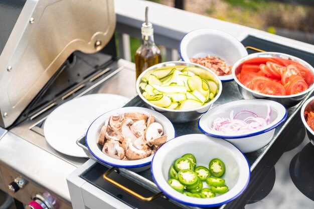 Cucinare la pizza su una griglia a gas all'aperto sul cortile in estate.