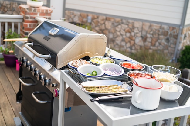 Cucinare la pizza su una griglia a gas all'aperto sul cortile in estate.