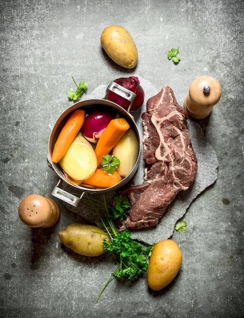 Cucinare la zuppa con verdure e carne. Sul tavolo di pietra.