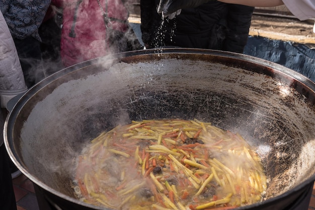 Cucinare pilaf in un grande calderone sulla strada Cucina asiatica