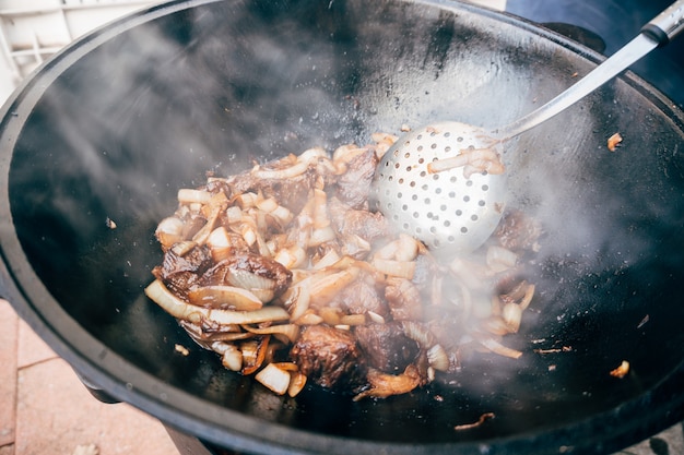 Cucinare plov nel calderone solo carne e cipolle in un calderone