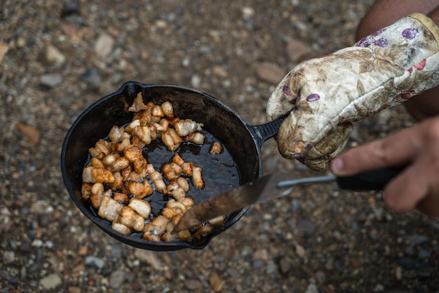 Cucinare su una griglia in pentole in ghisa all'aperto Patate alimentari rurali con lardo