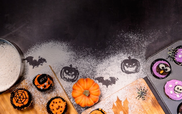 Cucinare una deliziosa torta fatta in casa e decorare cupcake per le feste di Halloween. Preparazione e miscelazione di ingredienti per dolci da dessert in cucina a casa.