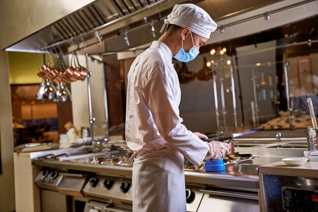 Cucinare usando un cannello a gas su una cucina