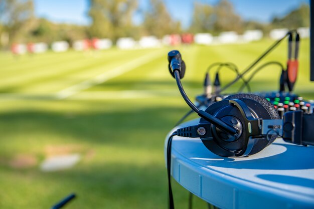 Cuffie commentatore sul tavolo accanto al campo di calcio. stream per televisione e radio