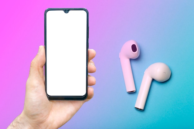 Cuffie con smartphone simulano cuffie audio audio su uno sfondo al neon colorato