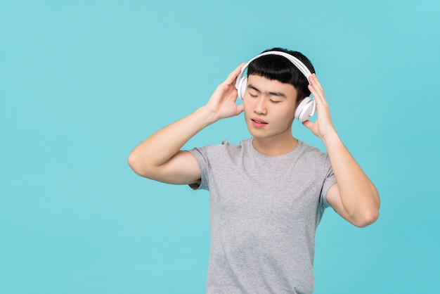 Cuffie d'uso dell'uomo asiatico che ascoltano la musica emozionale