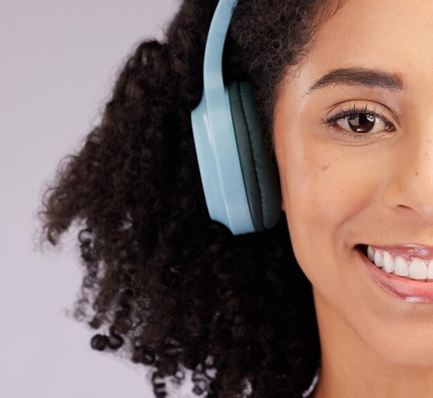 Cuffie donna felice e ritratto di sfondo studio mezza faccia e sfondo Closeup modello femminile sorriso e ascolto di musica audio e streaming multimediale per connessione audio podcast o radio