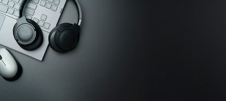 Cuffie e computer portatile sul desktop nero Ascolto del concetto di suono audio musicale