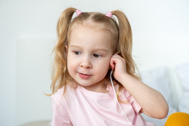 Cuffie felici del whith della bambina a casa