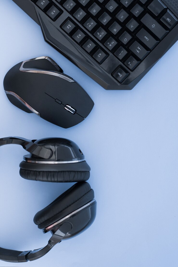 Cuffie, mouse, tastiera su sfondo blu, vista dall'alto. Attrezzatura da gioco. Area di lavoro del giocatore