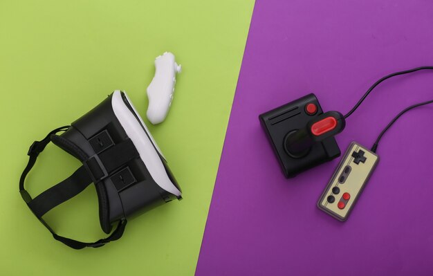 Cuffie per realtà virtuale, joystick e gamepad moderni e retrò su sfondo verde viola. Intrattenimento, videogiochi. Vista dall'alto