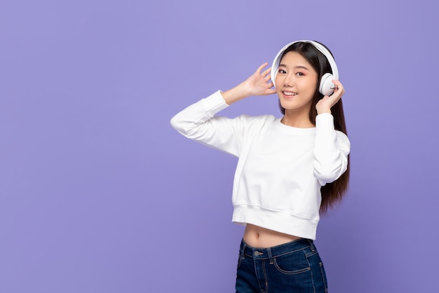 Cuffie sorridenti e commoventi della ragazza asiatica mentre ascoltando la musica e ballare