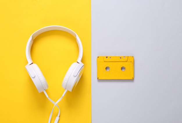 Cuffie stereo con cassetta audio su sfondo grigio giallo Natura morta retrò anni '80 Vista dall'alto