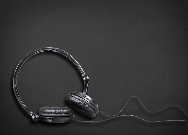 Cuffie su un tavolo di cuoio nero. Concetto musicale. Vista superiore con spazio di copia