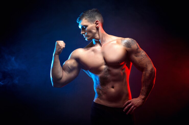 Foto culturista atletico bello dell'uomo di potere. corpo muscoloso fitness su sfondo scuro fumo. maschio perfetto. culturista fantastico, tatuaggio, posa.