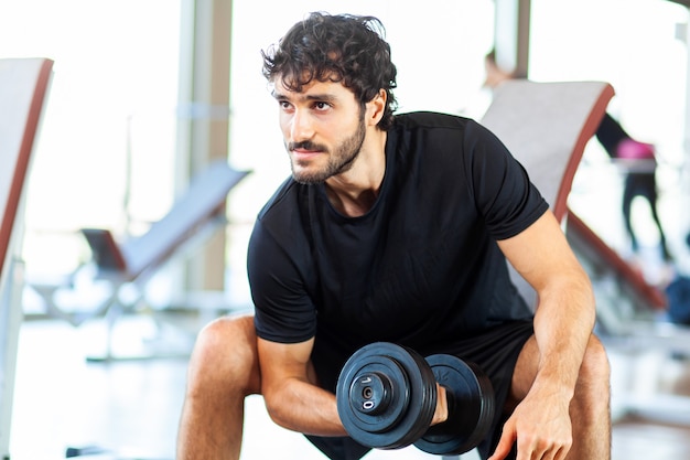 Culturista che usa un manubrio per allenare le braccia in palestra