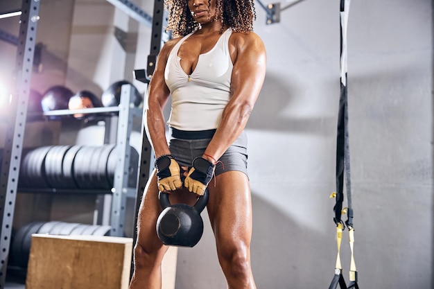 Culturista femminile che fa il singolo allenamento con kettlebell