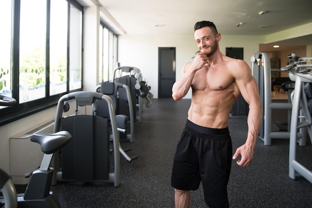 Culturista serio in piedi in palestra