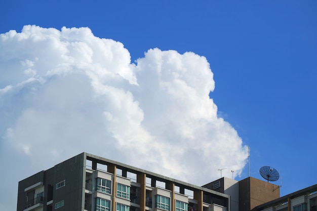 Cumuli gonfi bianchi lanuginosi su cielo blu vivo sopra le alte costruzioni a Bangkok, Tailandia