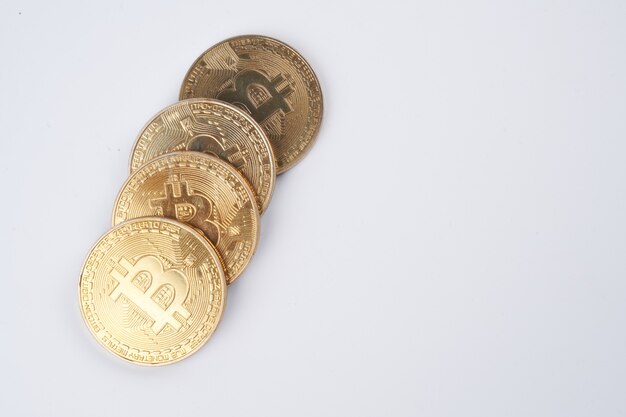 Cumulo di bitcoins dorati isolati su sfondo bianco da vicino con spazio di copia
