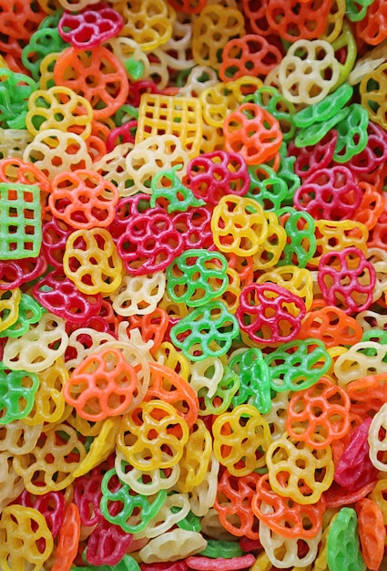 Cumulo di pasta colorata a forma di fiore crudo in vendita nel mercato