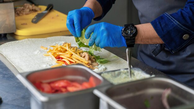Cuocere aggiungendo l'insalata in un involucro in un camion di cibo