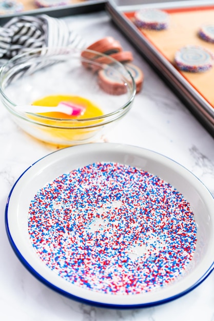 Cuocere i biscotti di zucchero girandola rossi, bianchi e blu per la celebrazione del 4 luglio.