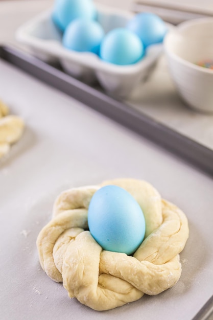 Cuocere il pane pasquale italiano con uova colorate di blu.