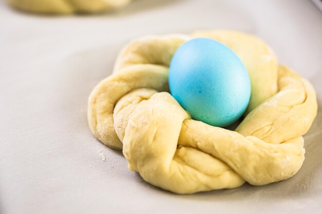 Cuocere il pane pasquale italiano con uova colorate di blu.