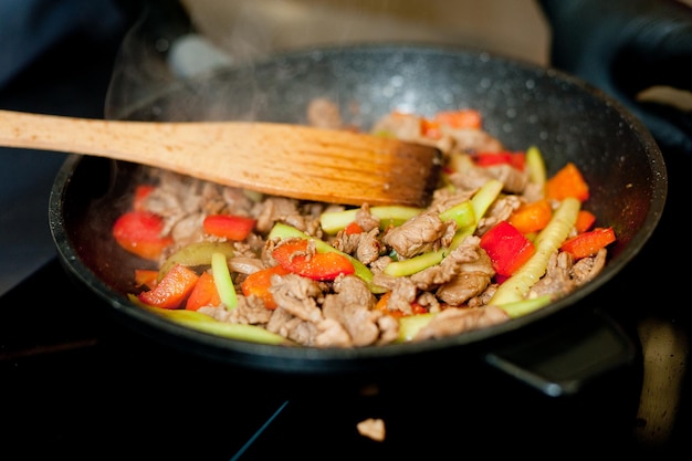 Cuocere la carne in padella con le verdure